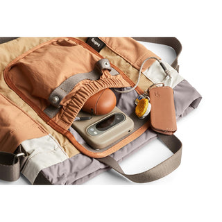 Bellroy Cinch Bucket Bag open flat showing organized interior with tan and gray recycled fabric