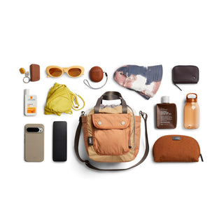 Bellroy Cinch Bucket Bag in tan with front pocket and durable recycled nylon fabric in flat lay style