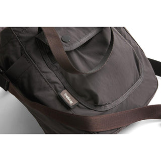 Bellroy Cinch Bucket Bag close-up showing textured recycled nylon fabric and secure button flap closure