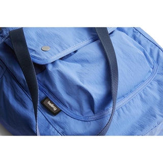 Bellroy Cinch Tote in blue recycled nylon fabric with black shoulder straps and front pocket detail