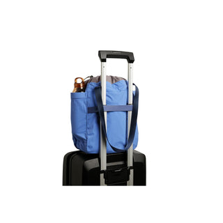 Bellroy Cinch Tote in blue fabric attached to suitcase handle with water bottle in side pocket