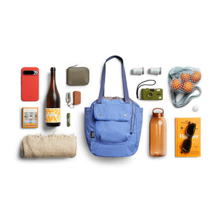 Bellroy Cinch Tote in blue recycled nylon with outdoor essentials neatly arranged around it