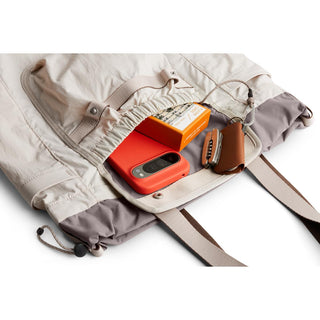 Bellroy Cinch Tote in beige with gray accents, showing organized interior with tech and accessories