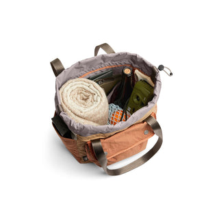 Bellroy Cinch Tote in earthy orange with spacious interior carrying rolled towel and outdoor gear
