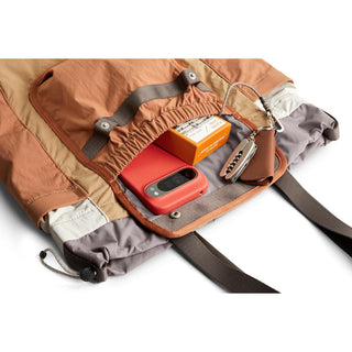 Bellroy Cinch Tote open showing organized interior with tech gadgets and accessories inside