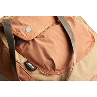 Bellroy Cinch Tote in peach and beige recycled nylon with grey shoulder straps and front flap pocket