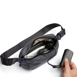 Bellroy Lite Belt Bag open showing organized interior with black textured recycled nylon fabric