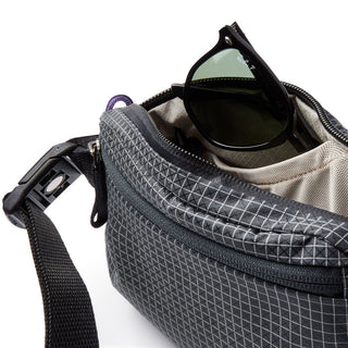 Bellroy Lite Belt Bag in black recycled fabric with zippered top and sunglasses inside compartment