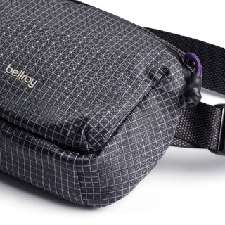 Bellroy Lite Belt Bag in black with geometric pattern and adjustable strap close-up view