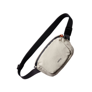 Bellroy Lite Belt Bag in light beige with black adjustable strap and textured recycled fabric