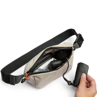 Bellroy Lite Belt Bag in beige recycled nylon with black strap open showing organized contents