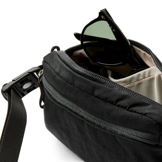 Bellroy Lite Belt Bag in black recycled fabric with sunglasses inside and adjustable strap visible