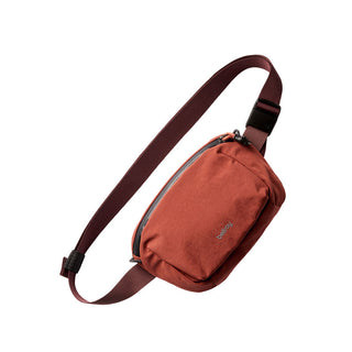 Bellroy Lite Belt Bag in rust red with adjustable burgundy strap and recycled fabric design