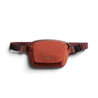 Bellroy Lite Belt Bag in rust red recycled fabric with compact front pocket and adjustable strap