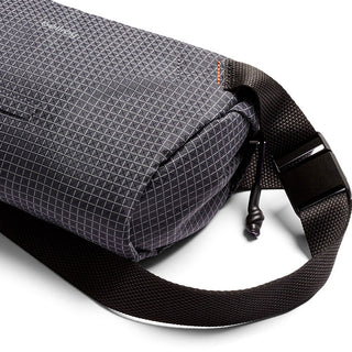 Bellroy Lite Sling Mini crossbody bag in dark fabric with textured grid pattern and adjustable strap