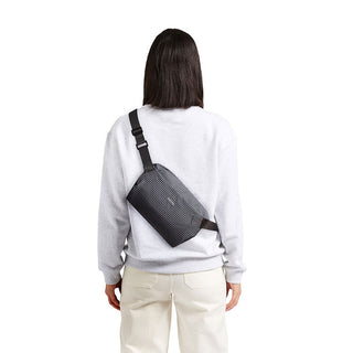 Bellroy Lite Sling Mini worn crossbody in textured black water-resistant recycled material