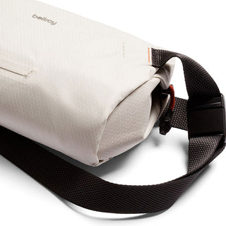 Bellroy Lite Sling Mini in light beige with textured fabric and adjustable black strap close-up view
