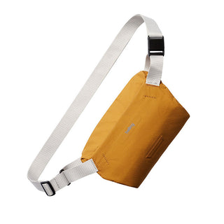 Bellroy Lite Sling Mini in mustard yellow with white adjustable strap and water-resistant recycled fabric design