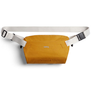 Bellroy Lite Sling Mini in mustard yellow with white adjustable strap made of recycled materials