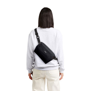 Bellroy Lite Sling Mini worn across back in black recycled water-resistant fabric