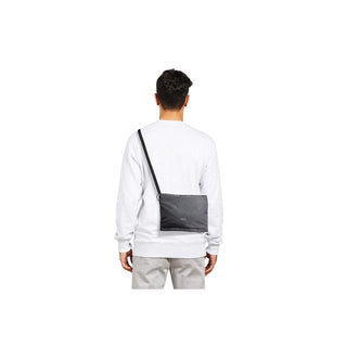 Bellroy Lite Sacoche in black recycled fabric worn crossbody by a person from back view