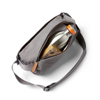 Bellroy Sling Mini Premium - 7L in gray woven fabric showing interior with water bottle and snack