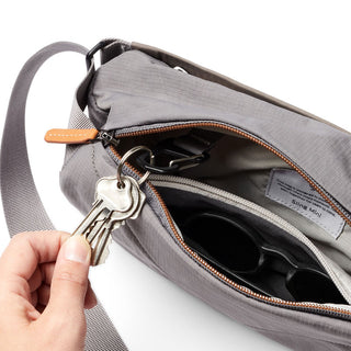 Bellroy Sling Mini Premium - 7L in grey with leather trim and interior key clip holding a keyring
