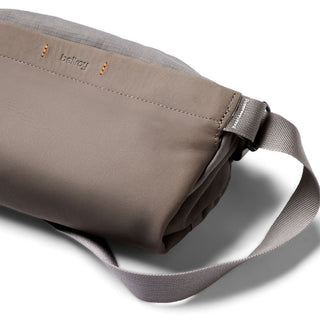 Bellroy Sling Mini Premium - 7L in muted taupe leather with adjustable woven strap and subtle logo embossing