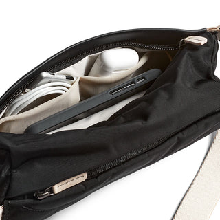 Bellroy Sling Mini Premium - 7L black sling bag showing organized interior with tech accessories and compartments