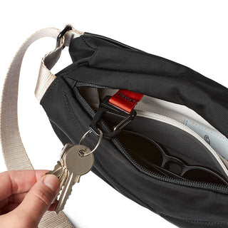 Bellroy Sling Mini Premium - 7L black crossbody bag with key clip and inner sunglasses pocket visible