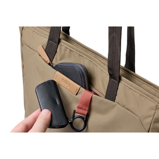 Bellroy Tokyo Tote Compact in beige woven fabric with front pocket holding small black accessories