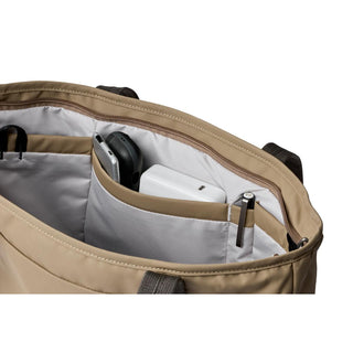 Bellroy Tokyo Tote Compact in beige showing organized interior pockets with tech accessories inside