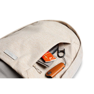 Bellroy Classic Backpack Second Edition in beige fabric with front pocket holding keys and small items