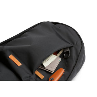 Bellroy Classic Backpack Second Edition with black recycled fabric and tan leather accents, partially open with contents visible