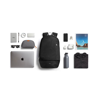 Bellroy Classic Backpack Premium in black with water bottle, tech accessories, and travel essentials laid out