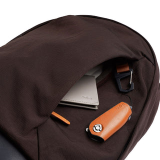 Bellroy Classic Backpack Premium in dark brown fabric with front pocket holding wallet and key holder