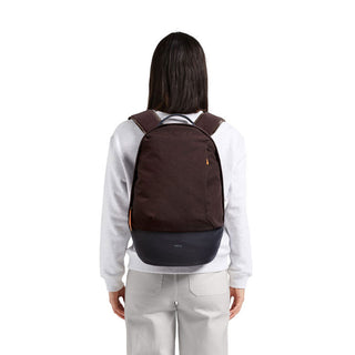 Bellroy Classic Backpack Premium in dark brown with black base worn on a person's back from rear view
