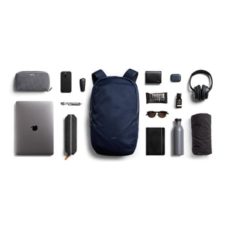 Bellroy Via Backpack in navy blue with sleek recycled fabric and organized travel essentials displayed around it