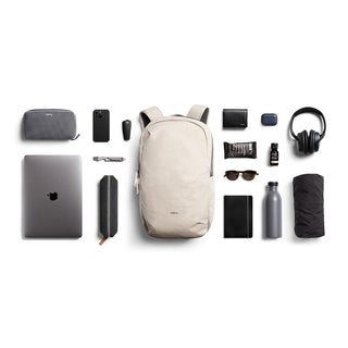Bellroy Via Backpack in light beige with sleek fabric surrounded by daily tech and travel essentials
