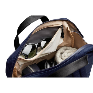 Bellroy Via Workpack open navy backpack showing sunglasses, knitwear, and internal pockets compartments