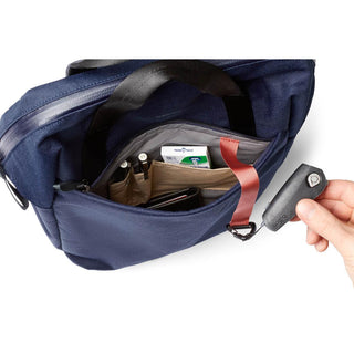 Bellroy Via Workpack navy bag interior with organized pockets and key holder accessory in hand