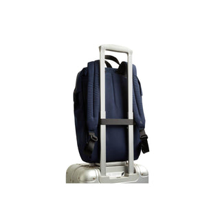 Bellroy Via Workpack navy backpack attached to silver suitcase handle from rear view