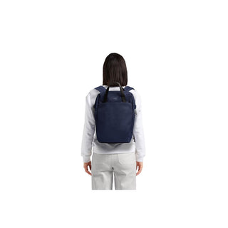 Bellroy Via Workpack navy blue backpack shown from back on person wearing white top and light pants