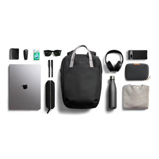 Bellroy Via Workpack black backpack with tech accessories and personal items neatly arranged on white background