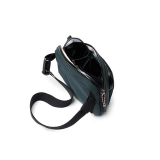 Bellroy Venture Hip Pack 1.5L in dark green with adjustable strap and partially open main compartment