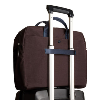 Bellroy Tokyo Work Bag in dark fabric attached securely to suitcase handle with strap detail