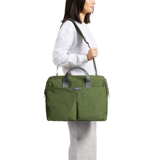 Bellroy Tokyo Work Bag in green recycled fabric carried crossbody by person in casual attire