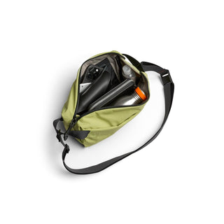 Bellroy Lite Sling in green showing organized interior with water bottle and tech accessories