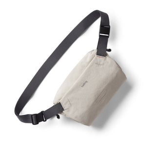 Bellroy Lite Sling Mini in light beige with adjustable black strap and water-resistant fabric texture