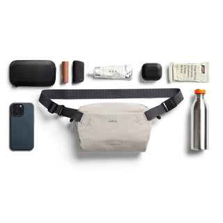 Bellroy Lite Sling Mini in light beige with adjustable black strap and compact water-resistant design